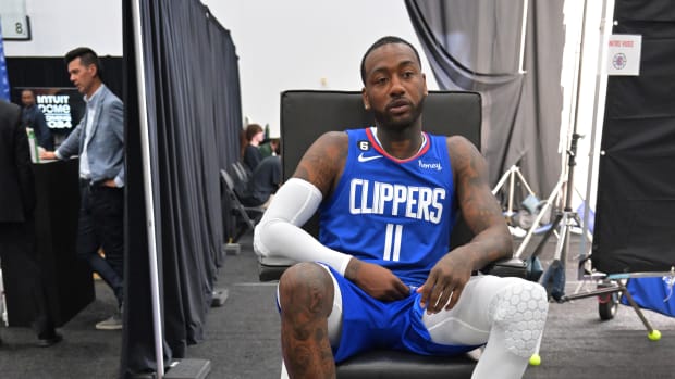 John Wall sits in front of sneaker collection.